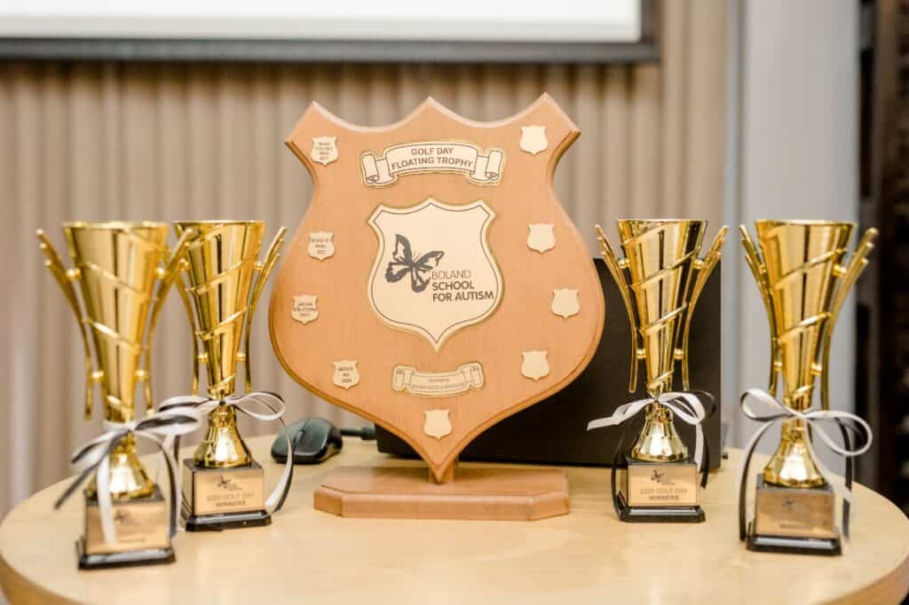 Autism awareness trophy with golf-themed awards and leadership recognition.