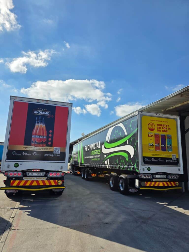 Provincial Logistics trucks with advertising trailers at a logistics hub under blue sky.